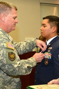 Maj. Gen. Glenn Curtis, adjutant general of the Louisiana National Guard, pins Air National Guard Staff Sgt. James Lam with a Bronze Star Medal with V Device during an official ceremony at Camp Beauregard in Pineville, La., Dec. 6, 2015. Lam earned the award based on his heroic achievement under direct enemy fire on Feb. 23, 2012, while assigned as a joint terminal attack controller, attached to the 1st Battalion, 179th Infantry Regiment in Afghanistan. (U.S. Army National Guard photo by Sgt. Noshoba Davis)