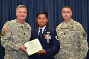 Maj. Gen. Glenn Curtis, adjutant general of the Louisiana National Guard, and Command Sgt. Maj. Robert Stiefvater, state command sergeant major of the Louisiana National Guard, present Air National Guard Staff Sgt. James Lam with a Bronze Star Medal with V Device during an official ceremony at Camp Beauregard in Pineville, La., Dec. 6, 2015. Lam earned the award based on his heroic achievement under direct enemy fire on Feb. 23, 2012, while assigned as a joint terminal attack controller, attached to the 1st Battalion, 179th Infantry Regiment in Afghanistan. (U.S. Army National Guard photo by Sgt. Noshoba Davis)