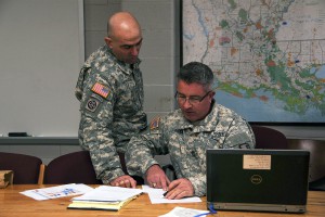 Sgt. Maj. Christopher Maxwell, operations sergeant major of the 225th Engineer Brigade, discusses operation plans with Master Sgt. Shawn Krill, assistant operations sergeant of the brigade. The brigade has been tasked with helping with levee patrols and providing equipment in response to the flooding of the Mississippi River. (National Guard Photo by Sgt. Noshoba Davis)