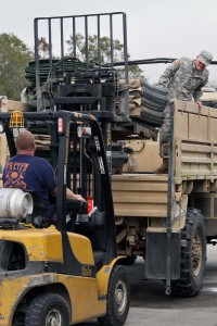 A Louisiana National Guardsman and local officials load HESCO barriers onto a light medium tactical vehicle to be used to construct a 12,550-foot long levee on Avoca Island in St. Mary Parish in advance of expected river flooding, Jan. 8, 2016. More than 100 Guardsmen are working around the clock on the project. (U.S. Army National Guard photo by Spc. Garrett Dipuma) 