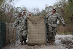 Louisiana National Guard Spc. Scott Mouton, of Baton Rouge, Spc. Mason Guidry, of Breaux Bridge, and other Guardsmen carry a HESCO barrier on Avoca Island near Morgan City, La., Jan. 9, 2016. The barrier will be used in the construction of a 2-mile long levee to prevent backwater flooding from reaching Morgan City and other towns in South Louisiana due to high river levels. (U.S. Army National Guard photo by Spc. Garrett L. Dipuma)
