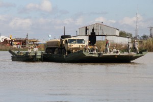 The Louisiana National Guard’s 2225th Multi Role Bridge Company ferries a fuel truck from Amelia, La., to Avoca Island to support a mission to build 2 miles of levees to protect Morgan City from backwater flooding due to high river levels, Jan. 9, 2015. (U.S. Army National Guard photo by Spc. Garrett L. Dipuma)