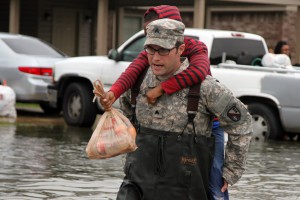 Sgt. Jason C. Carroll, electronic warfare specialist with the Louisiana National Guard's 528th Engineer Battalion, 225th Engineer Brigade, carries a young resident through flooded streets in Monroe, La, Mar. 10, 2016. The 528th used high-water vehicles, in cooperation with the Ouachita Parish Sheriff's Office, to navigate high waters to assist evacuating residents. (U.S. Army National Guard photo by Spc. Tarell J. Bilbo)