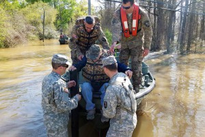 Members of the Louisiana National Guard's 2225th Multi-Role Bridge Company, 205th Engineer Battalion, help a resident from Watters Road in Ponchatoula, La., out of the bridge erection boat (BEB) they used to go door-to-door to check on residents that could not get out of their homes, March 13, 2016. The current of the river, which had overcome its banks and flooded the road, was too strong for regular boat motors to battle. (U.S. Army National Guard photo courtesy of 2225th Multi-Role Bridge Company)