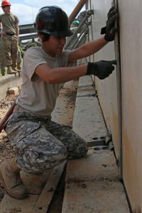 Spc. Elizabeth Fernandez, a Louisiana National Guardsman from the 1022nd Engineer Co. originally from Salem, Oregon, secures emergency barriers on the banks of the Ouachita River in Monroe, La., March 13, 2016. The 1022nd has been constructing the concrete levees to combat rising river levels caused by the excessive rainfall over the past few days. (U.S. Army National Guard photo by Spc. Garrett L. Dipuma)