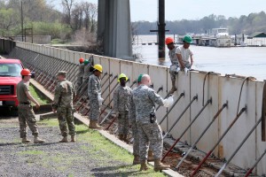 More than 15 Louisiana National Guardsmen from the 1022nd Engineer Co. and the 844th Engineer Co. out of West Monroe, La., are assembling emergency levee walls on the banks of the Ouachita River in Monroe, La., March 13, 2016, to protect the city from rising river levels caused by excessive rainfall. The Soldiers are working in conjunction with the Tensas Levee Basin District to transform half a mile of hinged concrete slabs, which are usually the sidewalk alongside the river, into a six foot tall levee. (U.S. Army National Guard photo by Spc. Garrett L. Dipuma)