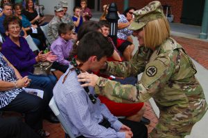 Blake Champagne is leid by Maj. Taysha Gibbs at his dad's (Col. Brian P. Champagne's) retirement ceremony at Jackson Barracks in New Orleans Nov. 5, 2016. Col. Champagne surprised his family during the ceremony, announcing that they are going to Hawaii as soon as his kids finish school. Champagne is retiring after 33 years of military service. (U.S. Army National Guard photo by Spc. Garrett L. Dipuma)