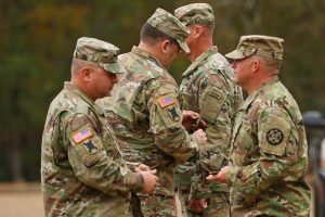 Lt. Col. William Rachal, commander of the Louisiana National Guard's 1st Battalion, 256th Infantry Brigade Comabt Team, prepares to put the 256th patch on Lt. Col. John Hollar, commander of the Alabama National Guard's 1st Battalion, 173rd Infantry Regiment at an official patching ceremony in Enterprise, Alabama, Dec. 3, 2016. (U.S. Army National Guard photo by Spc. Garrett L. Dipuma)