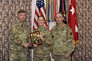 Staff Sgt. Nicole Bourgeois, 2016 TRADOC National Guard Instructor of the Year, 1st Battalion (Noncommissioned Officer Academy), 199th Regiment Regional Training Institute at Camp Cook in Ball, Louisiana, receives a plaque and congratulations from Gen. David Perkins, commanding general of U.S. Army Training and Doctrine Command, and Command Sgt. Maj. David Davenport, TRADOC senior enlisted leader, during the 2016 TRADOC Instructor of the Year ceremony at the Fort Eustis Club in Virginia, Aug. 3, 2017. (U.S. Army photo by Angel Clemons)