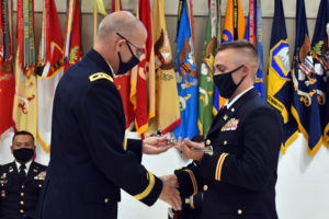 Maj. Gen. Keith Waddell, adjutant general of the Louisiana National Guard, presents Officer Candidate School honor graduate 2nd Lt. Andrew Broussard of Youngsville, Louisiana, with the Adjutant General's Award during the Officer Candidate School graduation ceremony at Camp Beauregard in Pineville, Louisiana, Aug. 8, 2021. Broussard was one of 15 officers commissioned during the ceremony and will be an officer with 225th Engineer Brigade. (U.S. Army National Guard photo by Staff Sgt. Thea James)