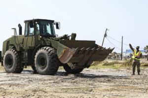 Soldiers of the 1023rd Engineering Company, 225th Engineer Brigade, assist in the removal of mud and debris from the main road after Hurricane Ida in Grand Isle, La., Sept., 5, 2021. Grand Isle was one of the hardest hit areas during Hurricane Ida. (U.S. Army National Guard photo by Sgt. Renee Seruntine)