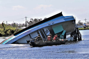 Lt. Cmdr. Adam Jones, an active-duty Naval salvage officer from Washington, D.C. and Louisiana National Guardsmen 2nd Lt. Stuart Coles and Spc. Michael Cotton, 156th Infantry Regiment, 256th Infantry Brigade Combat Team of Houma, Louisiana mark locations along Bayou Lafourche for future salvage missions in order to open it back up for transit, Sept 11, 2021. (U.S. Army National Guard photo by Staff Sgt. Gregory Stevens)