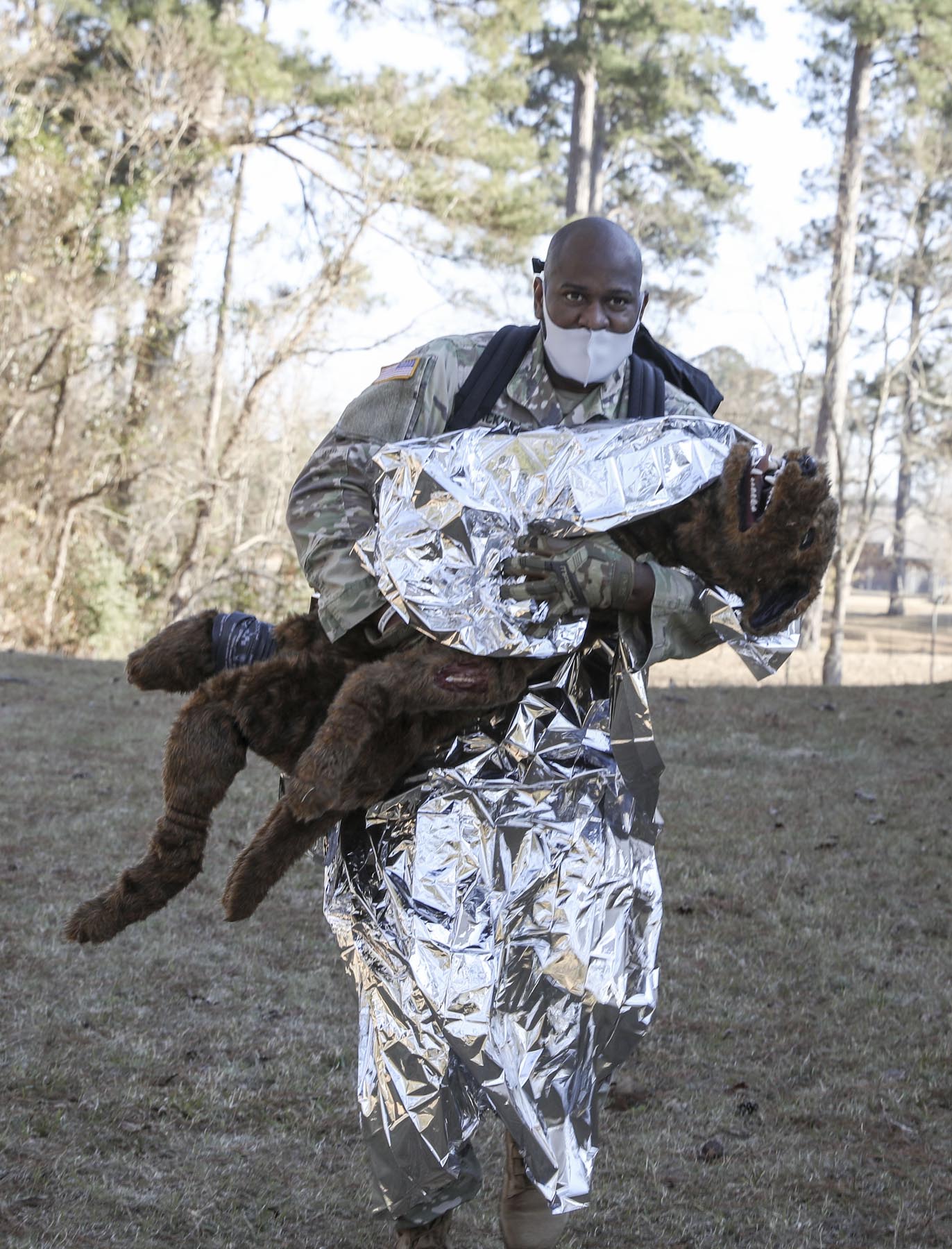 The Louisiana National Guard's Sgt. 1st Class Charles Blackwell, a medic with Headquarters and Headquarters Company 256th Infantry Brigade Combat Team, carries a fake training K9 to the medical evacuation point during a trauma lane exercise at Camp Beauregard in Pineville, La. on Jan. 29, 2022. The K9 Tactical Combat Casualty Care course was added to the LANG's medic sustainment training to teach medics how to properly treat a K9 on the battlefield when no vet is available. Blackwell is a Bogalusa, La. native and was one of 14 medics attending a 10-day medic sustainment course to renew his National Registry of Emergency Medical Technicians and CPR certifications. (U.S. Army National Guard photo by Staff Sgt. Noshoba Davis)